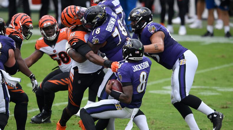 Cincinnati Bengals defensive end Carlos Dunlap (96) is able to sack Baltimore Ravens quarterback Lamar Jackson (8) in spite of being blocked by Ravens offensive tackle Orlando Brown (78) during the first half of an NFL football game, Sunday, Oct. 11, 2020, in Baltimore. (AP Photo/Nick Wass)