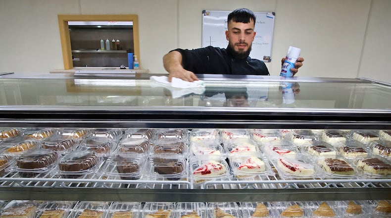 Moe Sabarna cleans the outside of the dessert case in his new Greek restaurant called East Greek And More Tuesday, Oct. 31, 2023 as he gets his new business ready to open in the former Mic's Italian Restaurant location. BILL LACKEY/STAFF