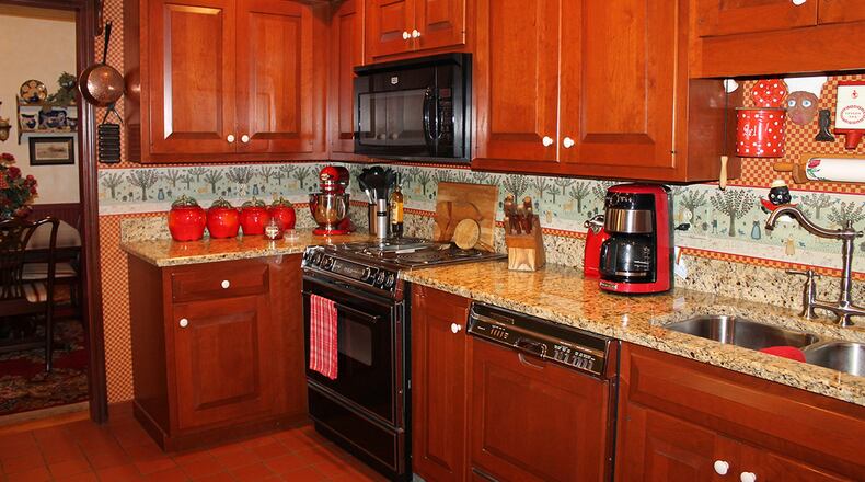 The kitchen features granite counter tops, cherry cabinetry, stainless-steel appliances and exposed beams.