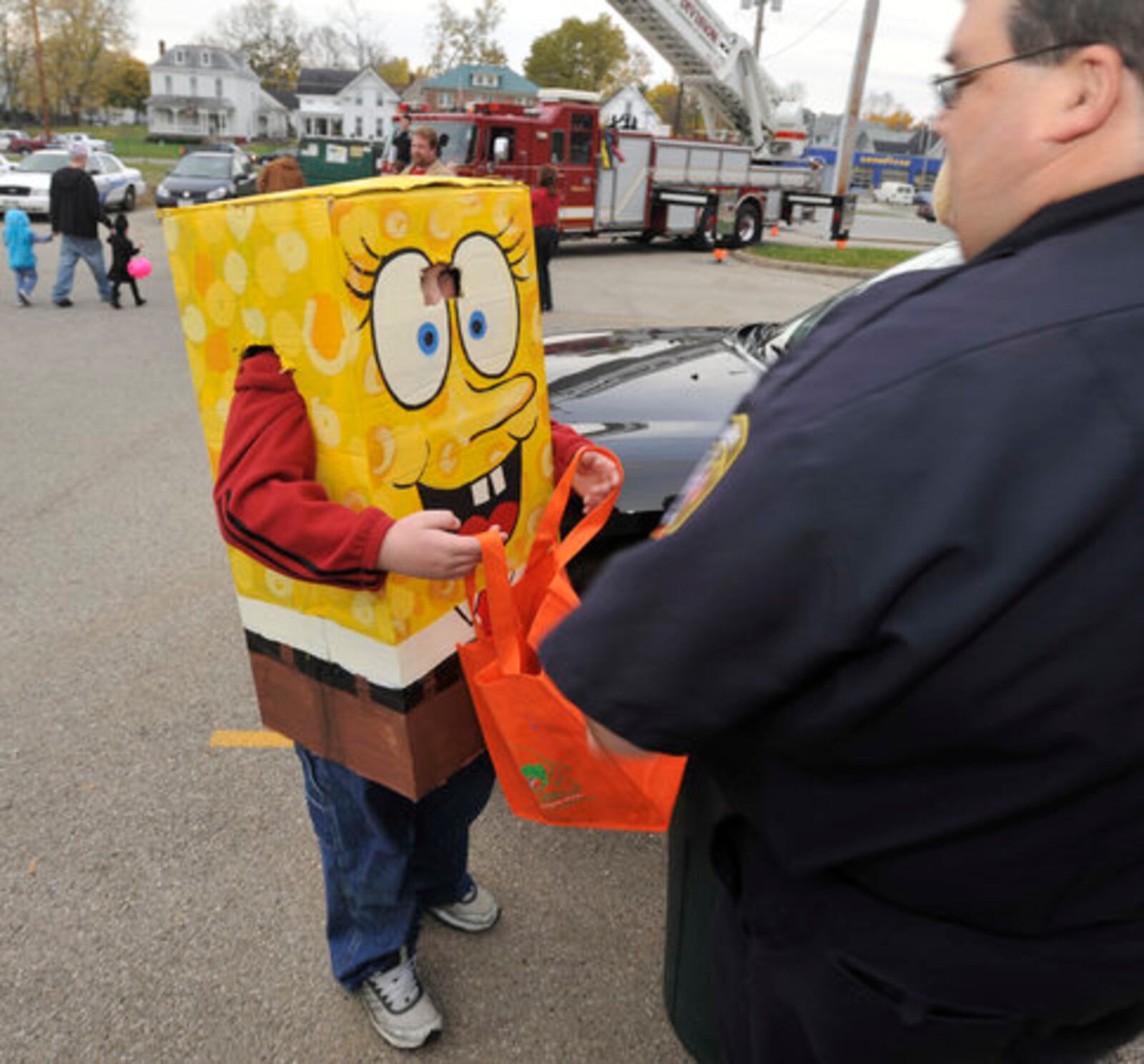 Children and their families trick-or-treat along Main Street in Urbana. STAFF FILE PHOTO