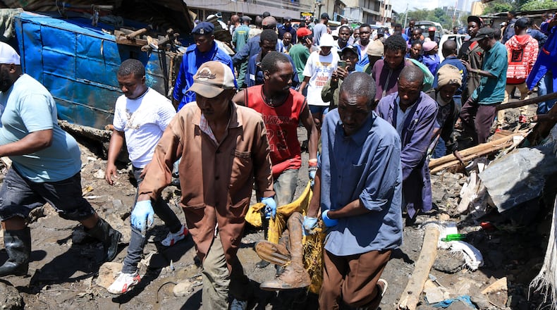 Volunteers carry the body of a man recovered after heavy rains in Nairobi, Kenya, Saturday, March 7, 2026. (AP Photo/Andrew Kasuku)