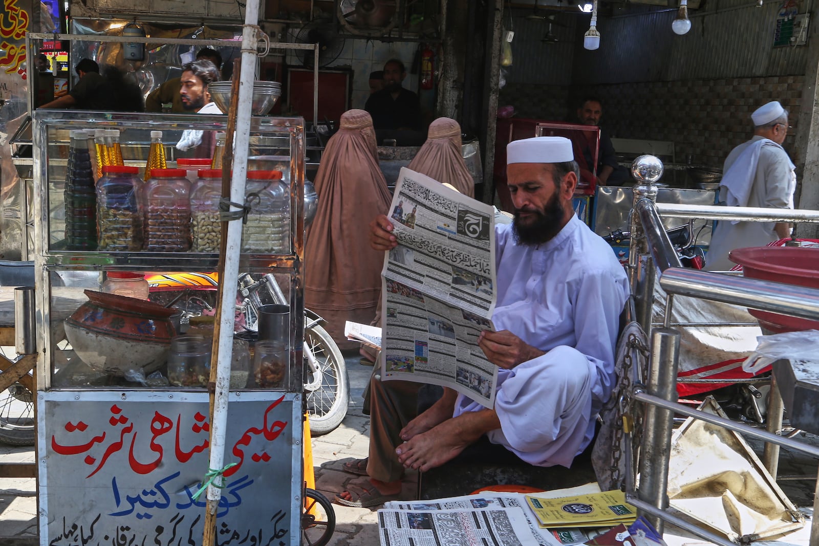 A Pakistani man reads morning news paper with front page story about Pakistan and India military tension, at a market in Peshawar, Pakistan, Friday, May 9, 2025. (AP Photo/Muhammad Sajjad)