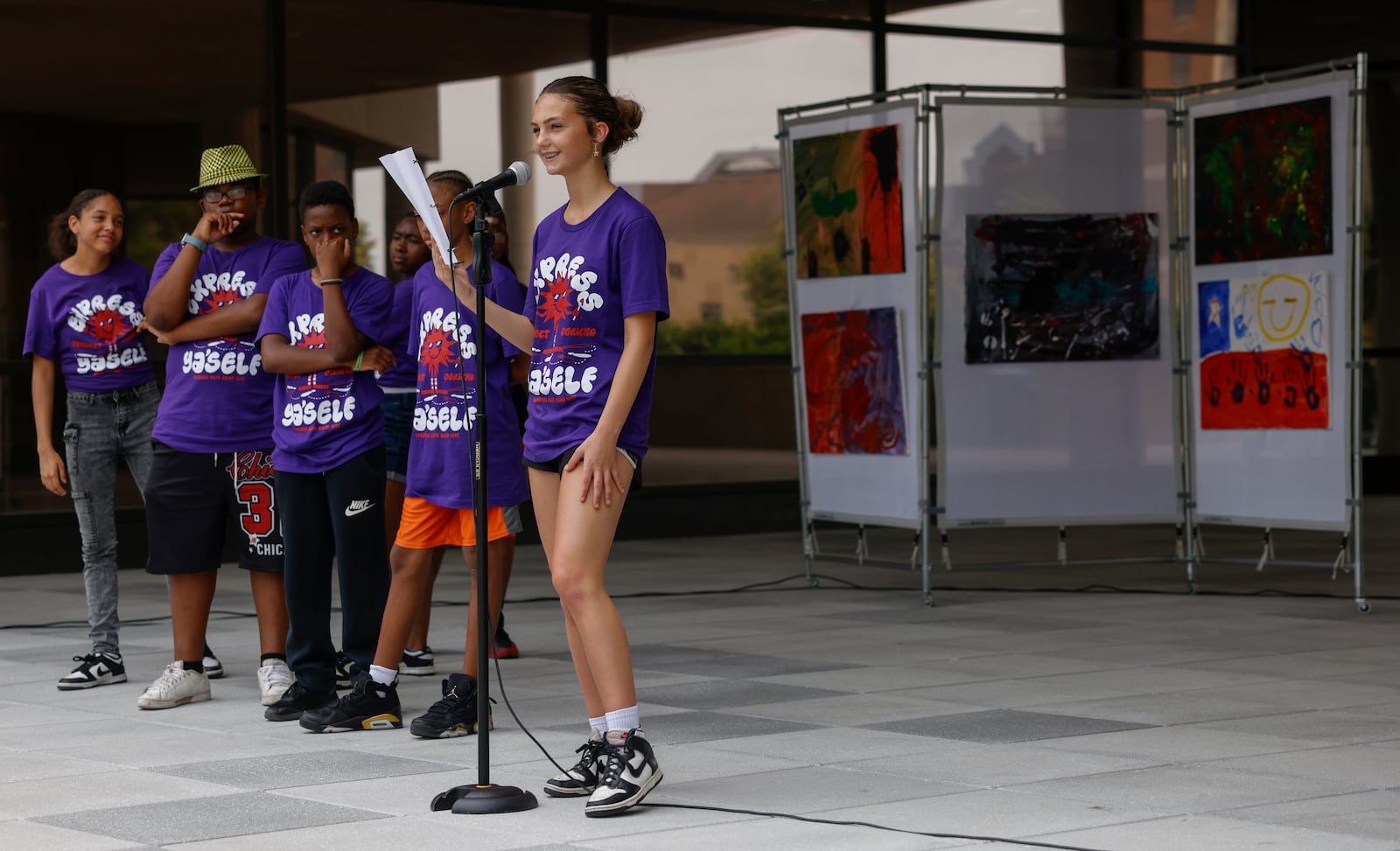 A kid reads a poem for an audience during Project Jericho Summer Arts Camp on Friday, June 13, 2025, at Springfield City Plaza. JOSEPH COOKE/STAFF