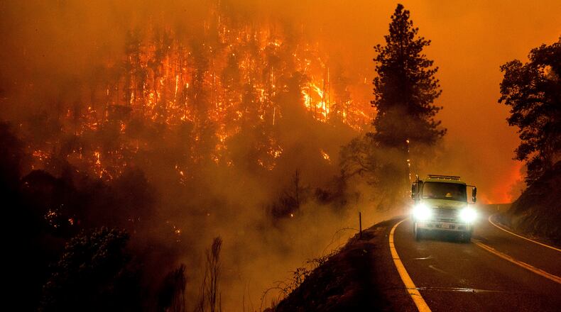 FILE - A firetruck drives along California Highway 96 as the McKinney Fire burns in Klamath National Forest, Calif., on July 30, 2022. (AP Photo/Noah Berger, File)