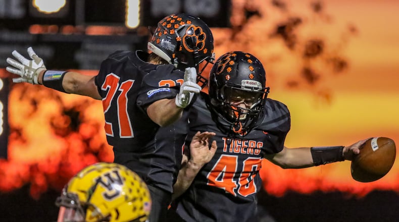 West Liberty-Salem juniors Nick Burden (21) and Isaiah McGill (40) celebrate after McGill scored a 22-yard touchdown during their game against West Jefferson on Friday night at Tiger Stadium. The Tigers won 42-39. CONTRIBUTED PHOTO BY MICHAEL COOPER