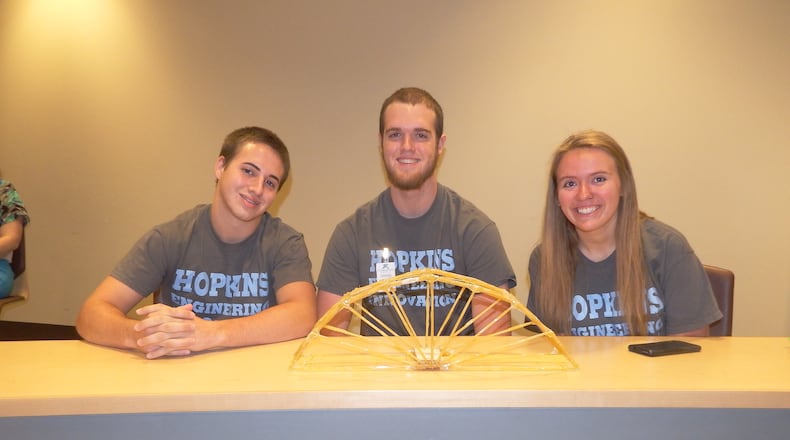 Nathan Bostick, Chris Lingane and Madison Crawford show off a bridge they built at one of the recent John Hopkins University engineering program classes. SUBMITTED PHOTO
