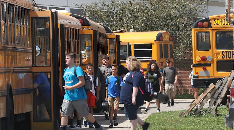 Students board school bus outside Shawnee High School as their released early due to the heat Thursday. Several area schools dismissed students early Tuesday due to the hot weather. BILL LACKEY/STAFF