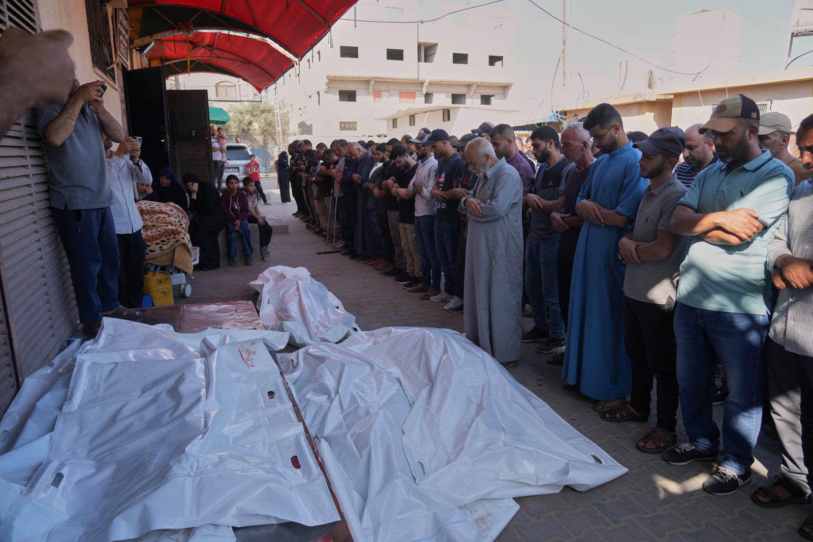 Palestinians pray over the bodies of people who were killed during an Israeli strike, at their funeral in Deir al-Balah, Gaza Strip, Wednesday, June 25, 2025. (AP Photo/Abdel Kareem Hana)