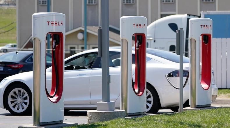 FILE - A Tesla charges at a station in Topeka, Kan., April 5, 2021. Tesla is turning to Mozambique for a key component in its electric car batteries in what analysts believe is a first-of-its-kind deal designed to reduce its dependence on China for graphite. Elon Musk’s company signed an agreement last month with Australia’s Syrah Resources, which operates one of the world’s largest graphite mines in the southern African country. (AP Photo/Orlin Wagner, File)