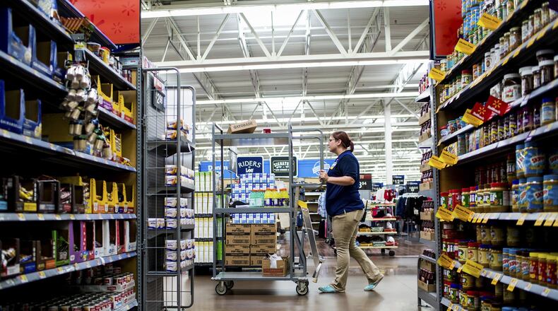 Ashley VanHorn, a grocery department dry goods manager, stocks shelves at the Walmart in Fulton, N.Y. Walmart is now using robots to help stock shelves at 50 stores across the country. (Roger Kisby/The New York Times)