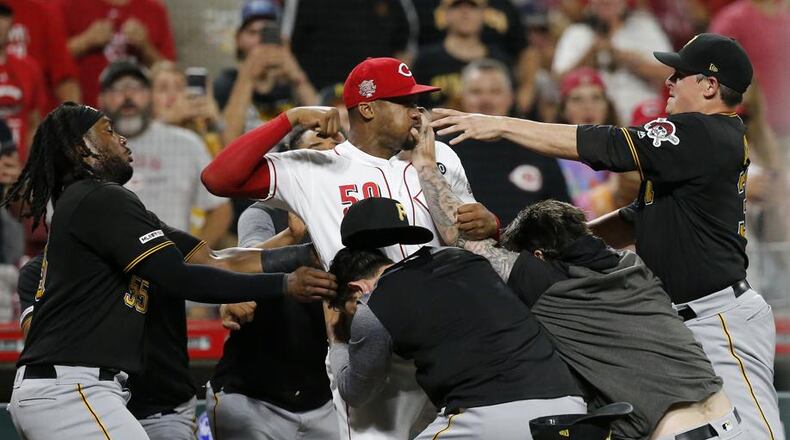 Cincinnati Reds relief pitcher Amir Garrett (50) looks to throw a punch as he is held back by a number of Pittsburgh Pirates players during a brawl in the ninth inning of a baseball game in Cincinnati on Tuesday, July 30, 2019. The Pirates won 11-4. (Sam Greene/The Cincinnati Enquirer via AP)