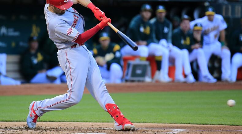 OAKLAND, CALIFORNIA - MAY 08: Curt Casali #12 of the Cincinnati Reds hits an RBI single during the second inning against the Oakland Athletics at Oakland-Alameda County Coliseum on May 08, 2019 in Oakland, California. (Photo by Daniel Shirey/Getty Images)