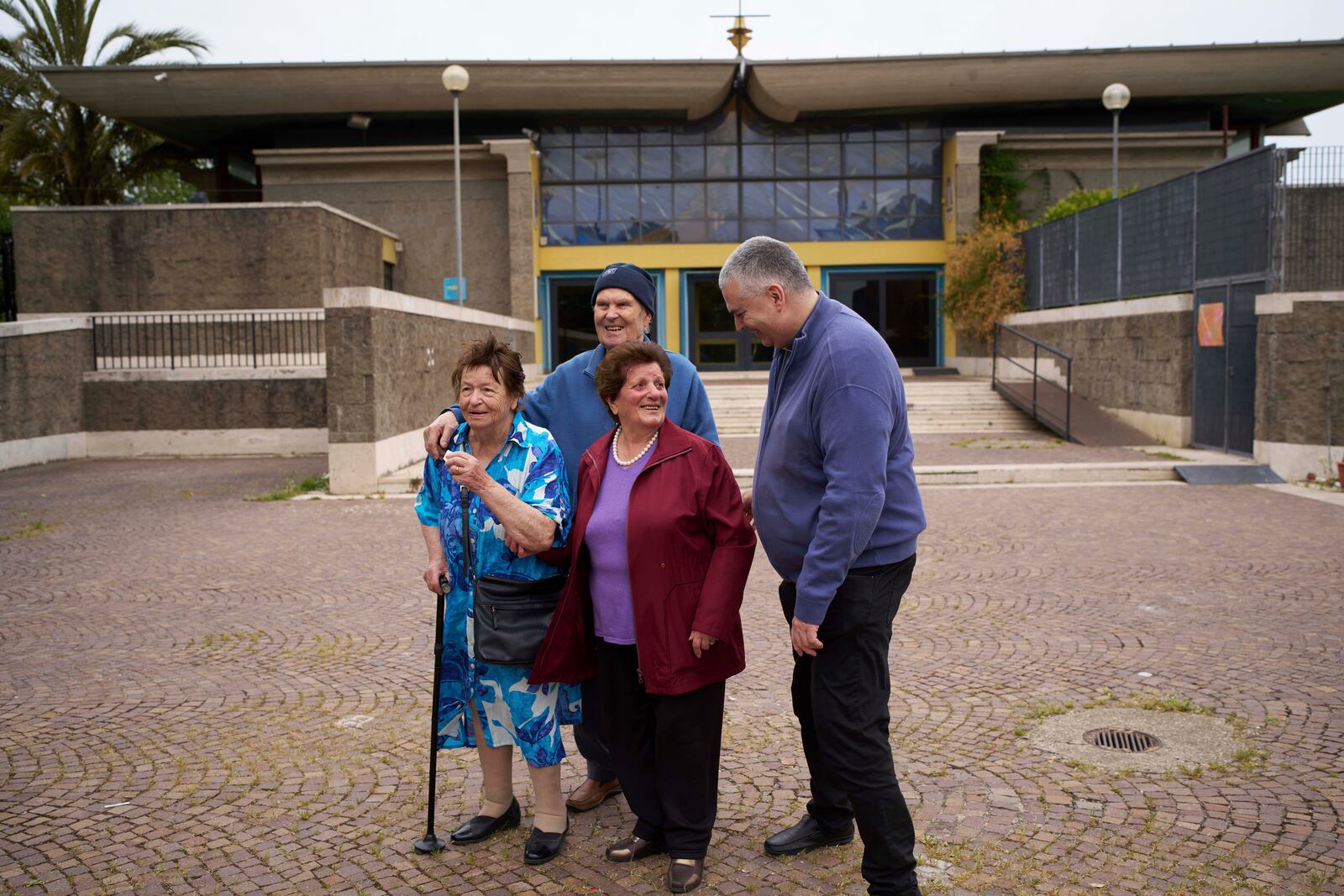 Father Roberto Cassano, right, shares a word with his parishioners Ida Di Giovannantonio, Maddalena Rughetti and Gavio Iachini, after a mass in San Paolo Della Croce parish church in Corviale neighbourhood, in Rome, Sunday, May 4, 2025. (AP Photo/Alessandra Tarantino)