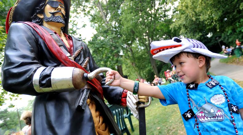 In this file photo, Parker Sothard, 4, shakes hands or hooks with the pirate statue at Veterans Park during the Parrothead Party in the Park as a warm-up to the Summer Arts Festival. BILL LACKEY/STAFF