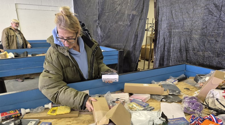 Nicole Bock, of Enon, hunts through a bin of goods at Nifty Thrifties Bargain Bins, 6845 Dayton Springfield Road, in search of bargains. MICHAEL KURTZ / STAFF