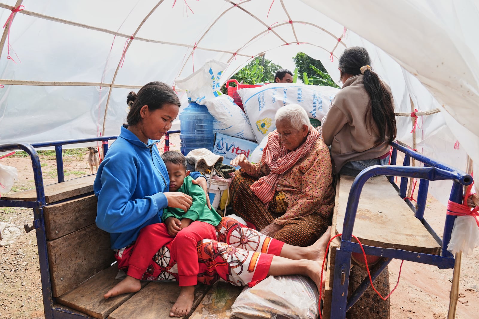 A Cambodian family sits on a tractor cart of as they return home from a temporary shelter in Prasat Roboeuk village, Oddar Meanchey province, Cambodia, Tuesday, July 29, 2025, after the ceasefire was supposed to take effect Monday night between Thailand and Cambodia. (AP Photo/Heng Sinith)