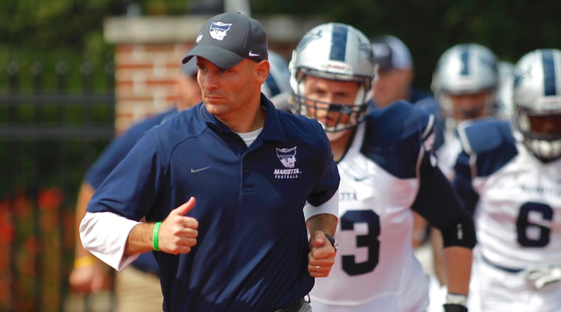 Marietta College head football coach Andy Waddle, a Greenon High School graduate and former defensive coordinator at Wittenberg, leads his team onto the field before a game at Otterbein on Saturday, Sept. 20, 2014, in Westerville. David Jablonski/Staff