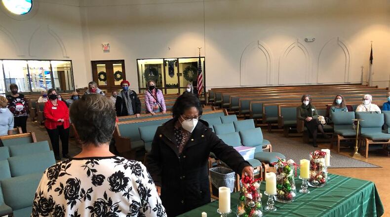 Debra Young accepts a bell to signify remembrance of her late spouse as part of the Hope for the Holidays event on Sunday that helped those coping with the loss of a loved one during the holiday season. Photo by Brett Turner