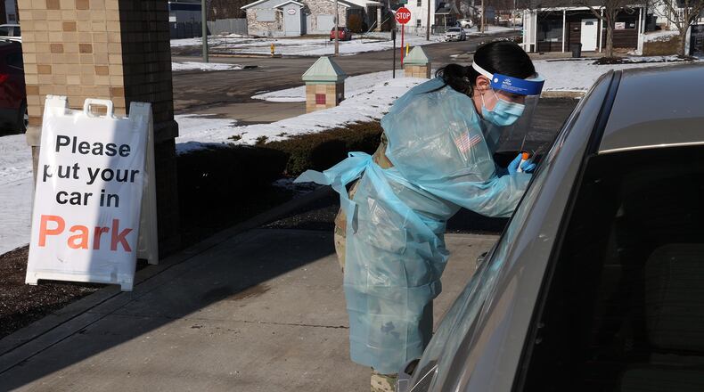 Weekly coronavirus cases drop again by nearly 100 in Clark and Champaign schools. Here, Cpl Hailey Cydrus of the National Guard gives a COVID test last month at the Clark County Combined Health District's Drive-Up COVID Testing Center. BILL LACKEY/STAFF