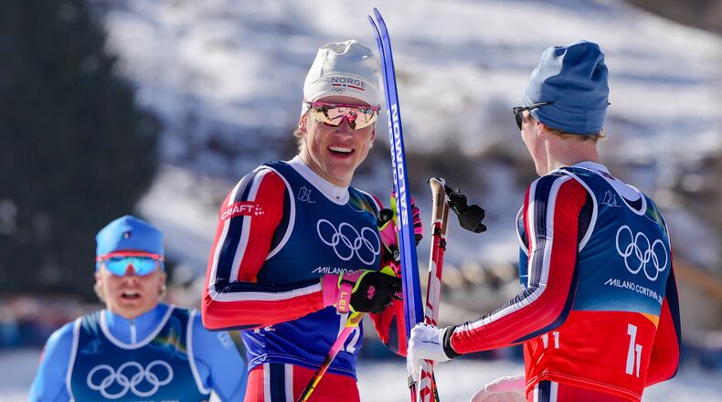 Johannes Hoesflot Klaebo, of Norway, center, speaks with teammate Einar Hedegart after winning the gold medal in the cross-country skiing men's team sprint free at the 2026 Winter Olympics, in Tesero, Italy, Wednesday, Feb. 18, 2026. (AP Photo/Kirsty Wigglesworth)