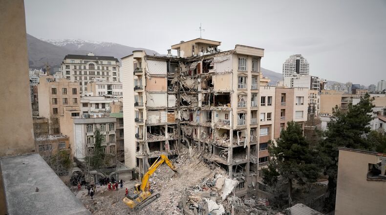 Iranian Red Crescent emergency workers use a bulldozer to clear rubble from a residential building that was hit in an earlier U.S.-Israeli strike in Tehran, Iran, Monday, March 23, 2026. (AP Photo/Vahid Salemi)