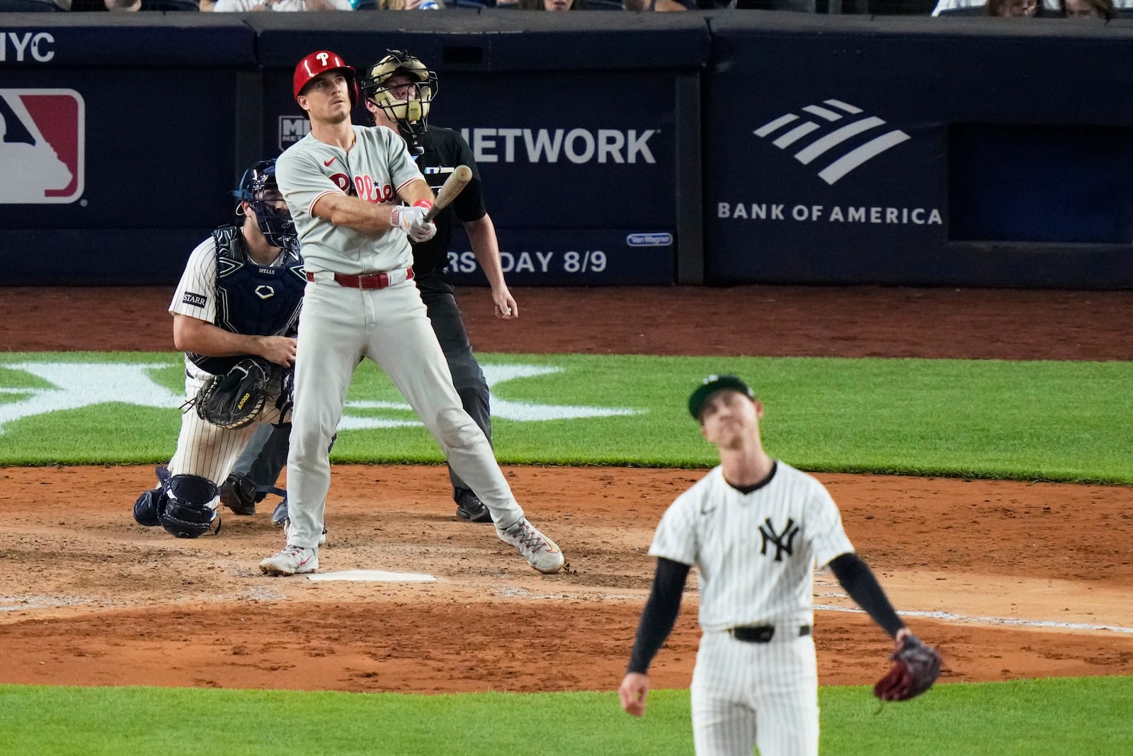 Philadelphia Phillies' J.T. Realmuto watches as ball he hit for a three-run home run as New York Yankees pitcher Luke Weaver reacts during the seventh inning of a baseball game Friday, July 25, 2025, in New York. (AP Photo/Frank Franklin II)
