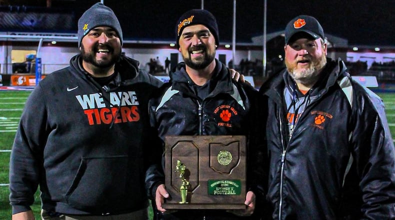 West Liberty-Salem High School coaches Andy McGill, Dan McGill and Jon McGill pose with the trophy after last week's Division V, Region 20 championship game at Piqua High School's Alexander Stadium. James Cropper/CONTRIBUTED
