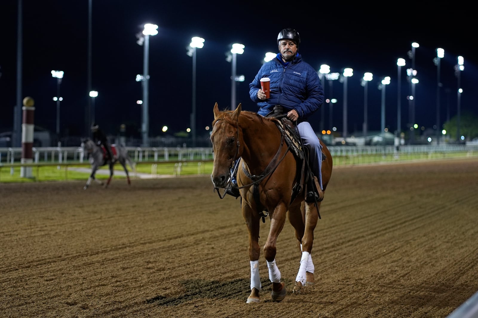 Trainer Steve Asmussen rides back to his barn after watching a workout at Churchill Downs Monday, April 28, 2025, in Louisville, Ky. (AP Photo/Charlie Riedel)