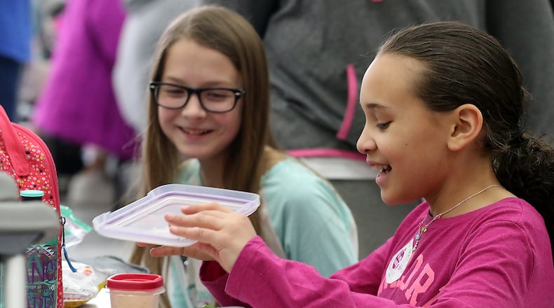 Alicia Gulasa, left, and Brooklyn Bishop share a laugh during lunch at Snyder Park Elementary Friday after learning about National No One Eats Alone Day. Bill Lackey/Staff