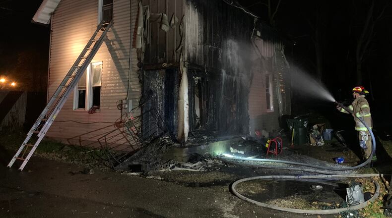 Fire heavily damaged a two-story house on Weimer Street Friday evening, Nov. 20, 2020, in Springfield. BILL LACKEY/STAFF