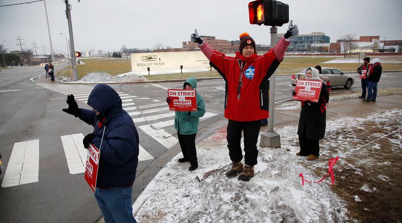 Senior math lecturer Karen Brackenridge stands atop a frozen snow pile in front of Wright State. Striking members of Wright State Universitys faculty union continued to picket on Thursday, the third day of the strike. Most classes continued to operate with some consolidated, some taught by substitutes, and others taught online. TY GREENLEES / STAFF