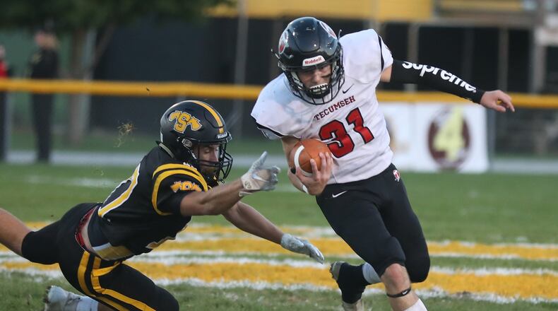 Tecumseh’s Lucas Rodgers avoids a tackle by Shawnee’s Pete Mueller as he carries the ball. BILL LACKEY/STAFF