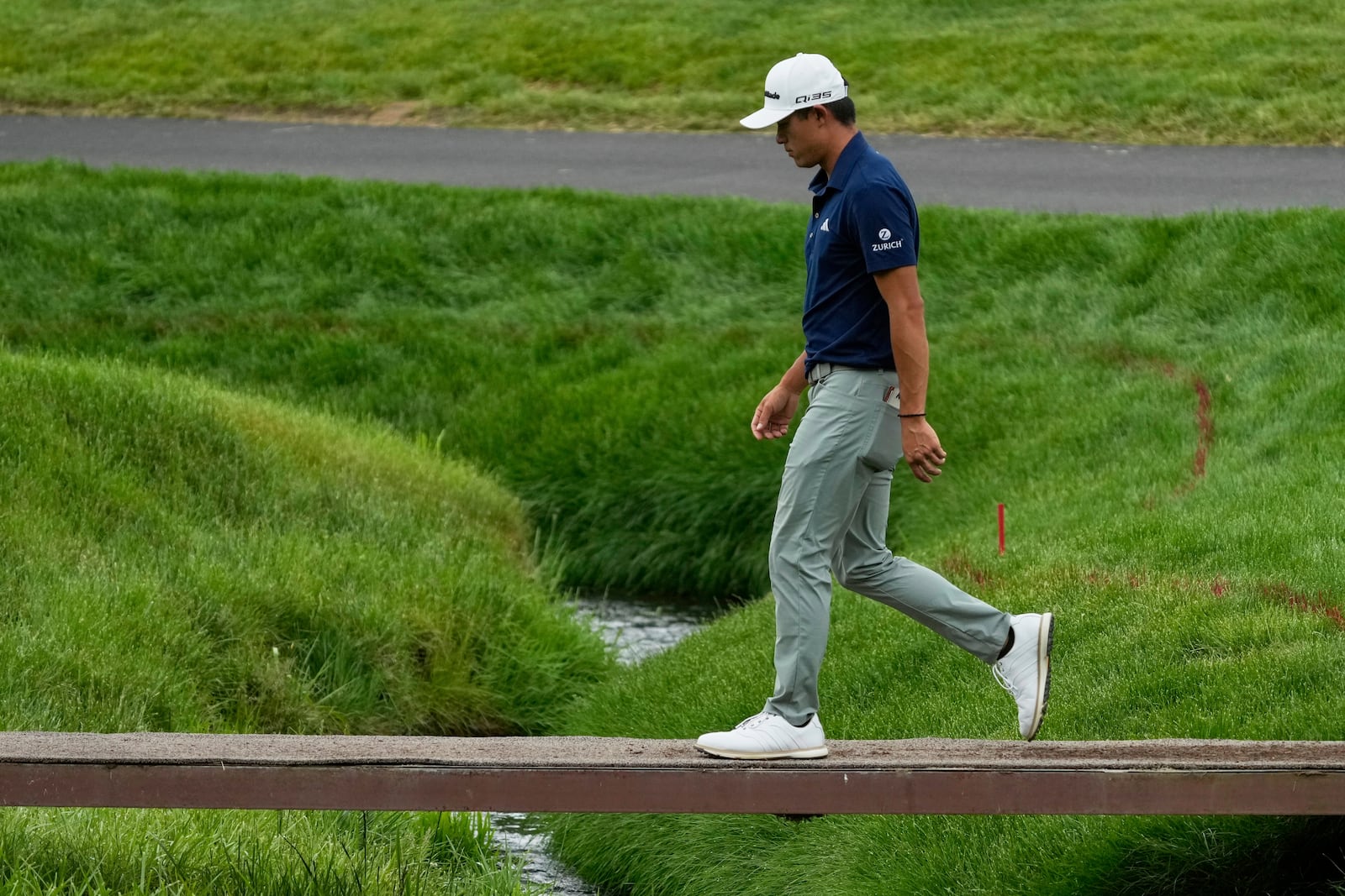 Collin Morikawa walks across a bridge on the second hole during the first round of the Memorial golf tournament, Thursday, May 29, 2025, in Dublin, Ohio. (AP Photo/Sue Ogrocki)