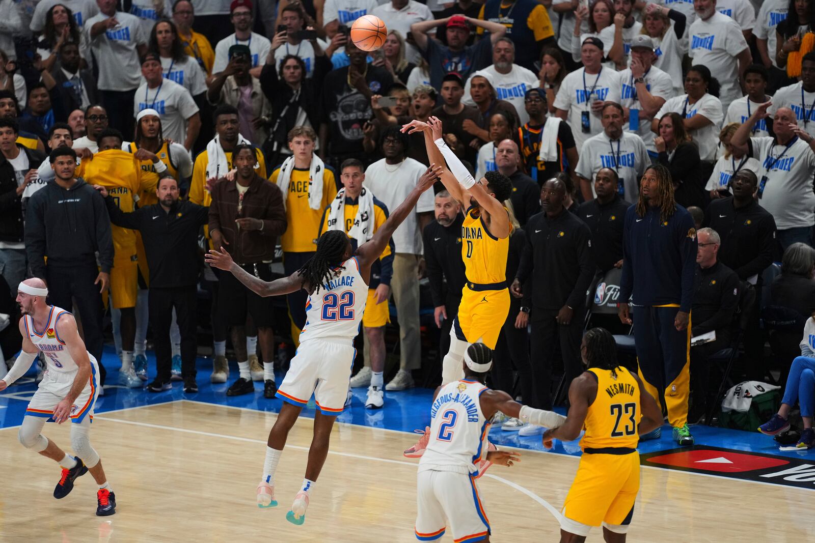 Indiana Pacers guard Tyrese Haliburton (0) shoots a 3-pointer against Oklahoma City Thunder guard Cason Wallace (22) during the second half of Game 1 of the NBA Finals basketball series Thursday, June 5, 2025, in Oklahoma City. (AP Photo/Nate Billings)