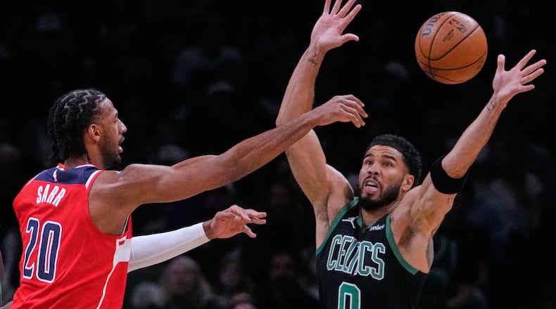 Boston Celtics forward Jayson Tatum (0) reaches up to block a pass by Washington Wizards center Alex Sarr (20) during the first half of an NBA basketball game, Saturday, March 14, 2026, in Boston. (AP Photo/Charles Krupa)