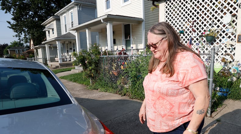 Dee Flack looks over her car as she cleans up after her neighbor, who lived in the house beside hers, was shot Tuesday night in front of her duplex in the 600 block of York Street in Springfield. Flack said she had just went to bed when she heard the shots outside. BILL LACKEY/STAFF