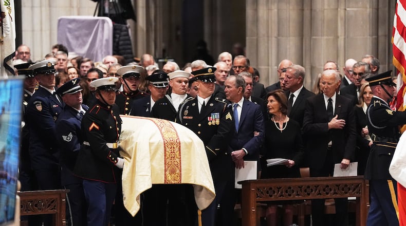 Former Presidents front row from left, George W. Bush with Laura Bush and Joe Biden with Jill Biden, look on as military pall bearers arrive with the casket of former Vice President Dick Cheney at the Washington National Cathedral, Thursday, Nov. 20, 2025 in Washington. (AP Photo/Matt Rourke)