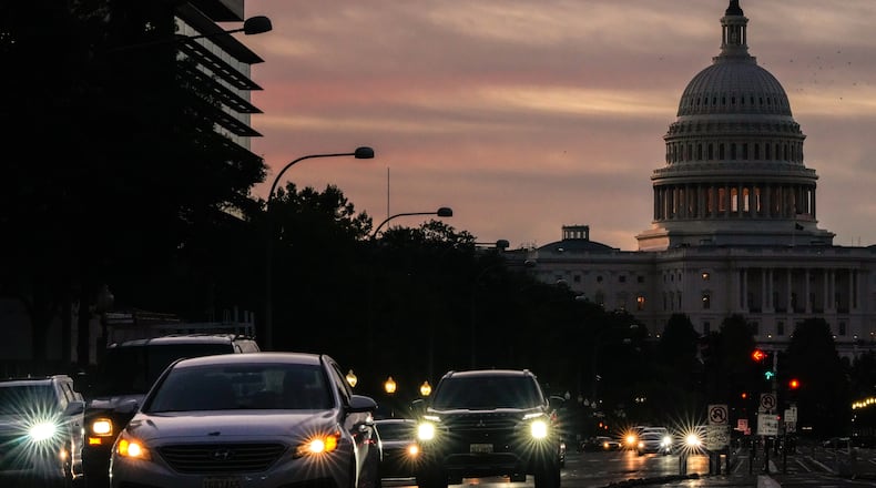 FILE - Vehicles drive along Pennsylvania Ave. during rush hour traffic at sunrise Wednesday, Oct. 1, 2025, in Washington, with the U.S. Capitol in the background. (AP Photo/Julia Demaree Nikhinson, File)