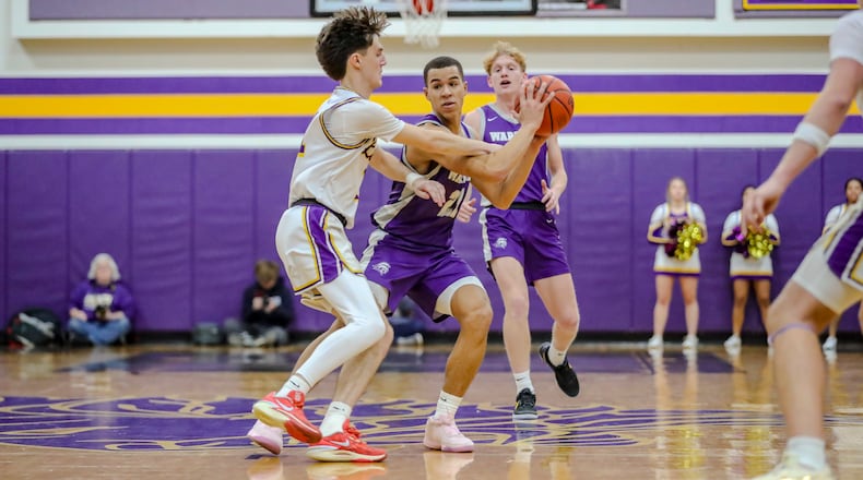 Dayton Christian High School junior Brayden Kidd is guarded by Emmanuel Christian senior Jayden Pinkleton during their game on Friday night in Springfield. Kidd had 29 points as the Warriors won 63-50. MICHAEL COOPER/CONTRIBUTED