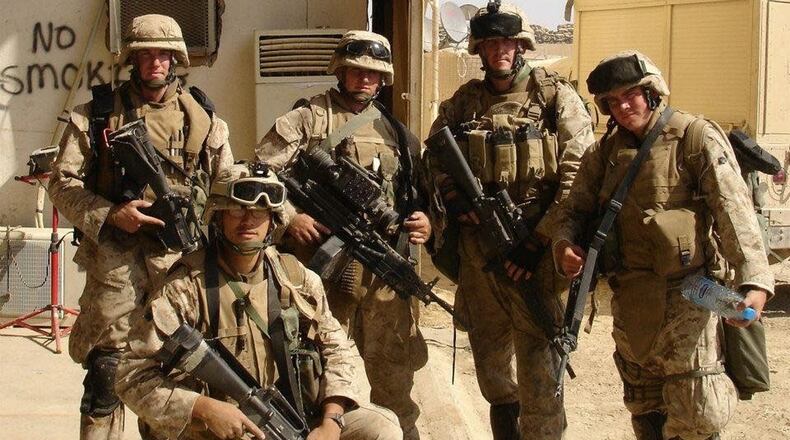 Christian Bussler kneels in front of his Marines in a photo taken after a mission in Iraq. CONTRIBUTED PHOTO
