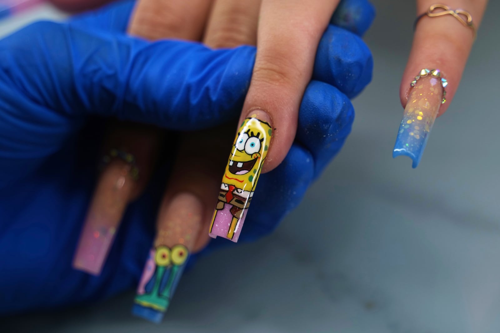 Manicurist Marisel Darias Valdes works on a client's nails in Havana, Cuba, Tuesday, June 24, 2025. (AP Photo/Ramon Espinosa)