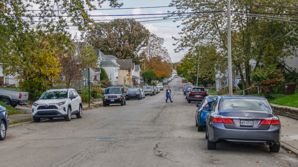 A mailman walks past the scene of a deadly stabbing in the 1500 block of Highland Avenue on Friday, Oct. 31, 2025, in Springfield. JOSEPH COOKE/STAFF