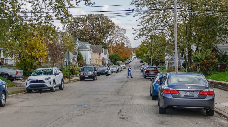 A mailman walks past the scene of a deadly stabbing in the 1500 block of Highland Avenue on Friday, Oct. 31, 2025, in Springfield. JOSEPH COOKE/STAFF