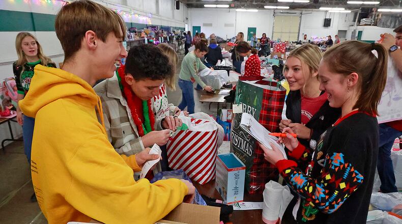 Students from the Global Impact STEM Academy, volunteered Wednesday, Dec. 7, 2022 at the Springfield Salvation Army's "Toy Store" at the Clark County Fairgrounds. GISA students, from left, Daniel Stacy, Jason Purdue, Ansley Turner and Josie Jennings helped gather toys and other items for children of families that requested assistance from the Salvation Army this year for Christmas. The Springfield Salvation Army is supplying gifts for nearly 3000 children this year. BILL LACKEY/STAFF