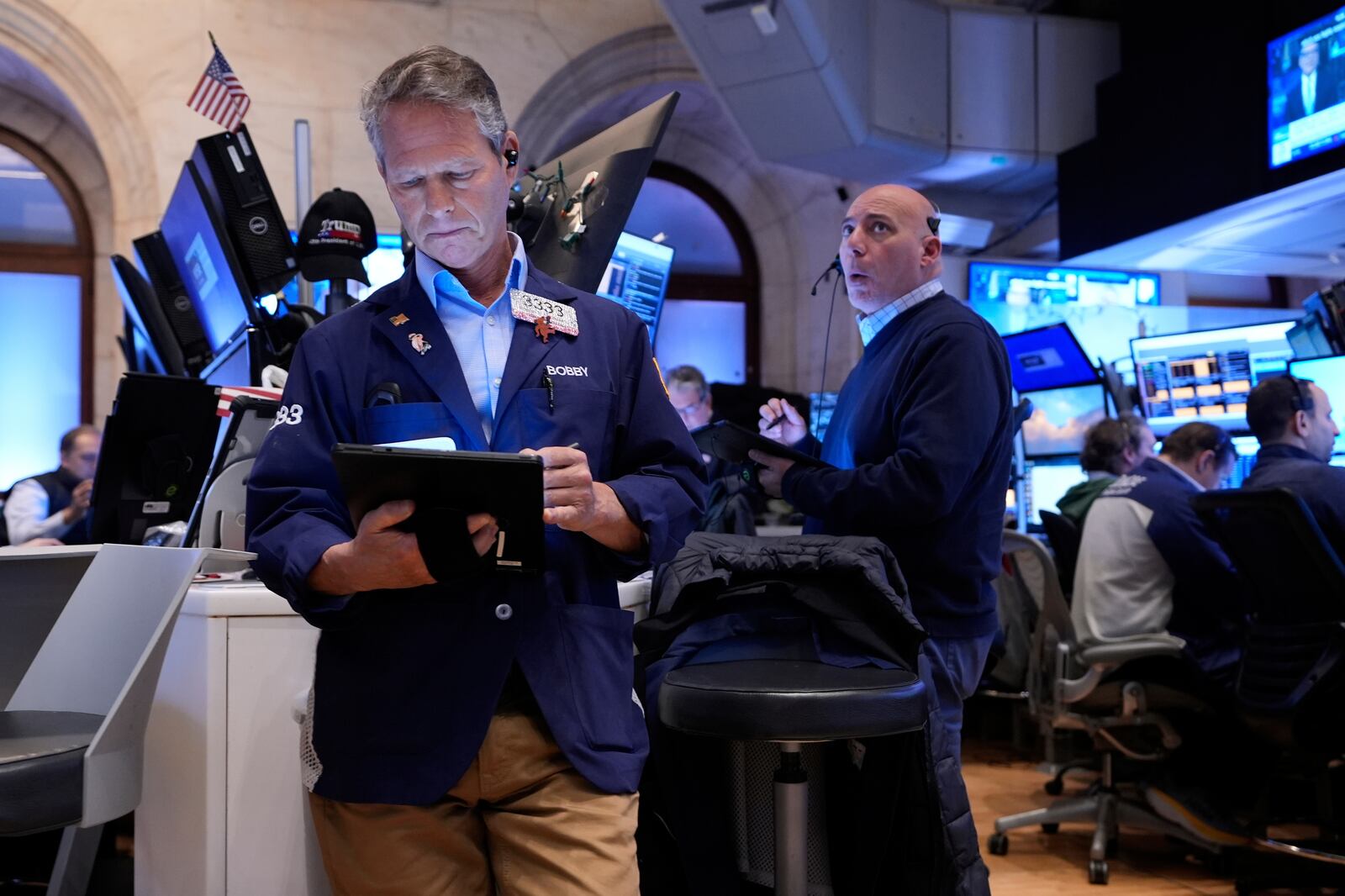 Bobby Charmak, left, and others work on the floor at the New York Stock Exchange in New York, Monday, April 7, 2025. (AP Photo/Seth Wenig)