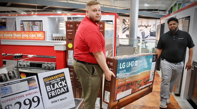 Huber Heights Big Sandy Superstore employees, Chad Stapp, left, and Steven Finch, move a 55 inch TV, Wednesday, Nov. 22, 2023 that is on sale Black Friday for $299. MARSHALL GORBY\STAFF