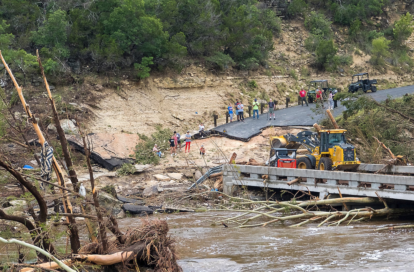 Crews work to clear debris from the Cade Loop bridge along the Guadalupe River on Saturday, July 5, 2025, in Ingram, Texas. (AP Photo/Rodolfo Gonzalez)