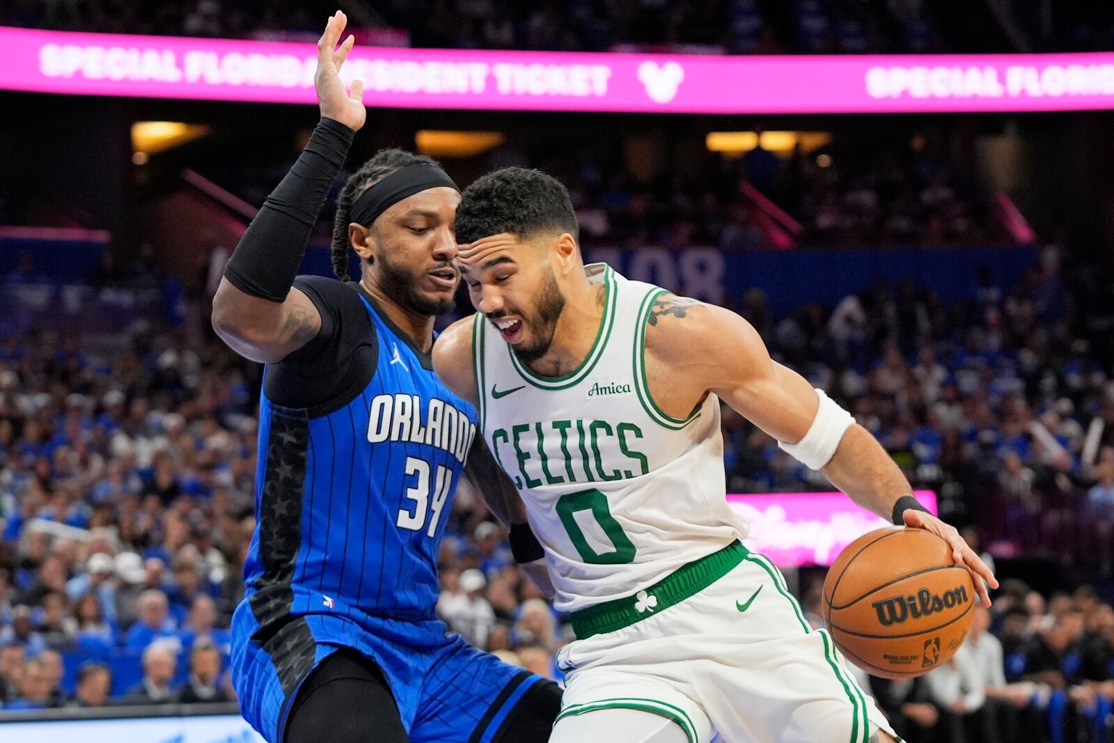 Boston Celtics forward Jayson Tatum (0) drives past Orlando Magic center Wendell Carter Jr. (34) during the first half in game 3 of a first-round NBA playoff basketball series,, Friday, April 25, 2025, in Orlando, Fla. (AP Photo/John Raoux)