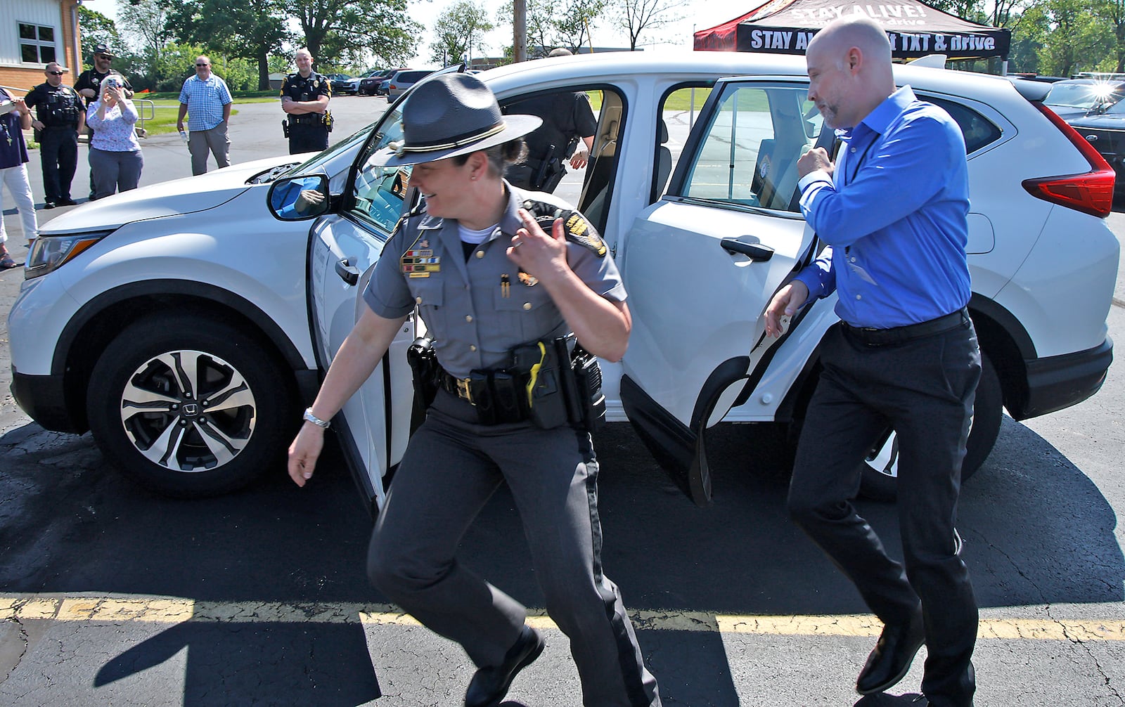 Members of area law enforcement and the Clark County Combined Health District participated in a "Quick Click Challenge" Thursday, May 16, 2024 during the Click It or Ticket campaign kick-off at the Health Department. During the challenge, four participants are timed as they quickly change positions in a car and buckle their seat belts in each seat.  BILL LACKEY/STAFF