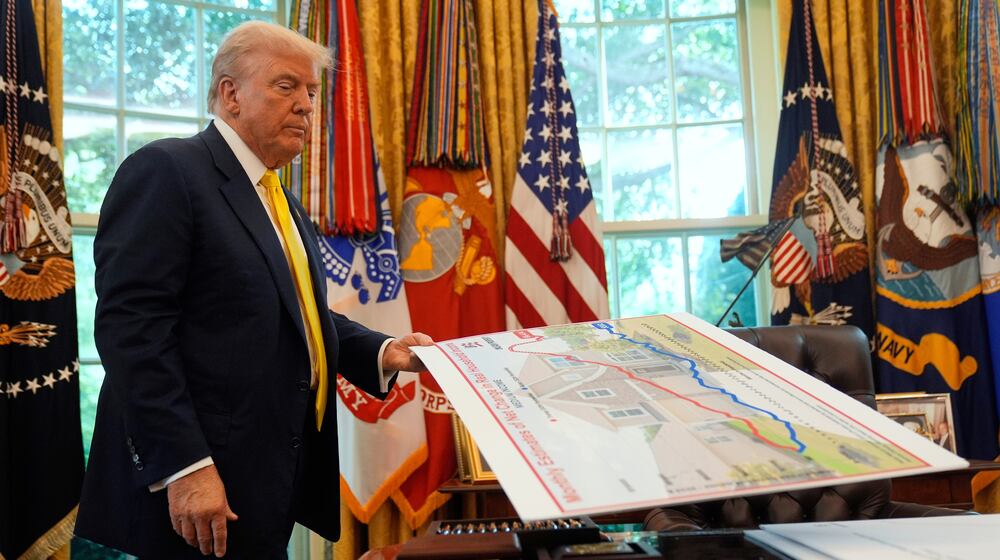 FILE - President Donald Trump holds a chart as he discusses the economy in the Oval Office of the White House, Aug. 7, 2025, in Washington. (AP Photo/Mark Schiefelbein, File)